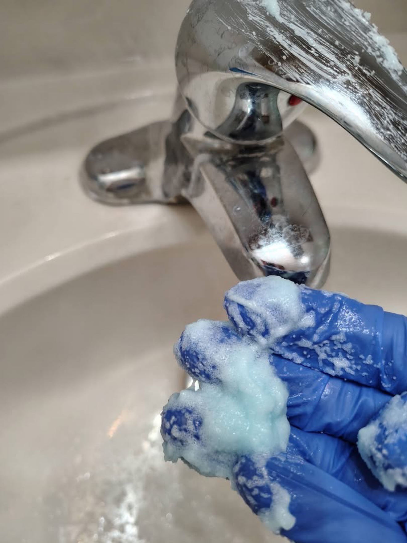 Bathroom faucet being treated with cleaner